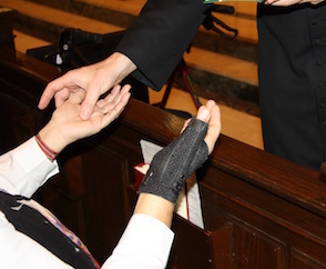 Anointing hands of Sick Person with oil.