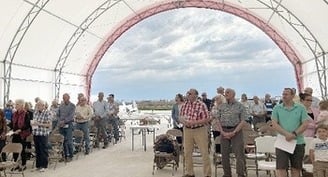 Congregation feels the Holy Spirit in the wind during Mass, blessing of seeds on Iowa family farm