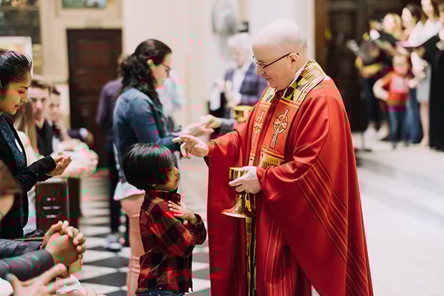 Receiving a Eucharistic blessing from Fr. Philip Kelly at St. Francis de Sales, Manhattan.