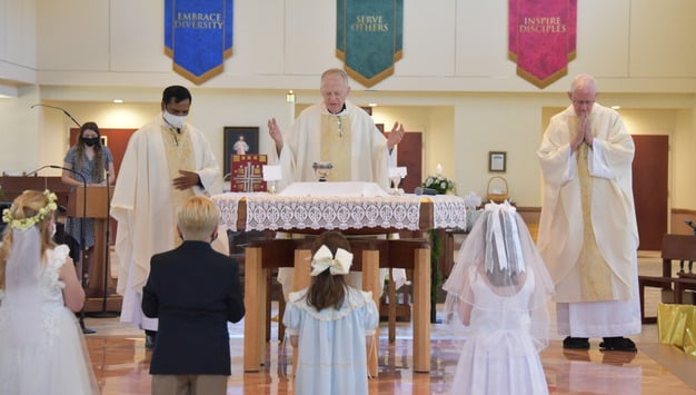 image of first communicants with priests