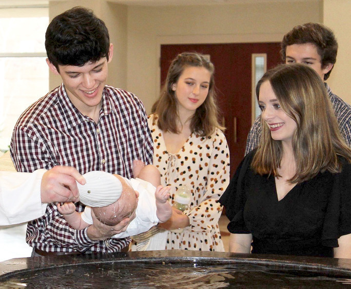 image of parents holding child at baptism