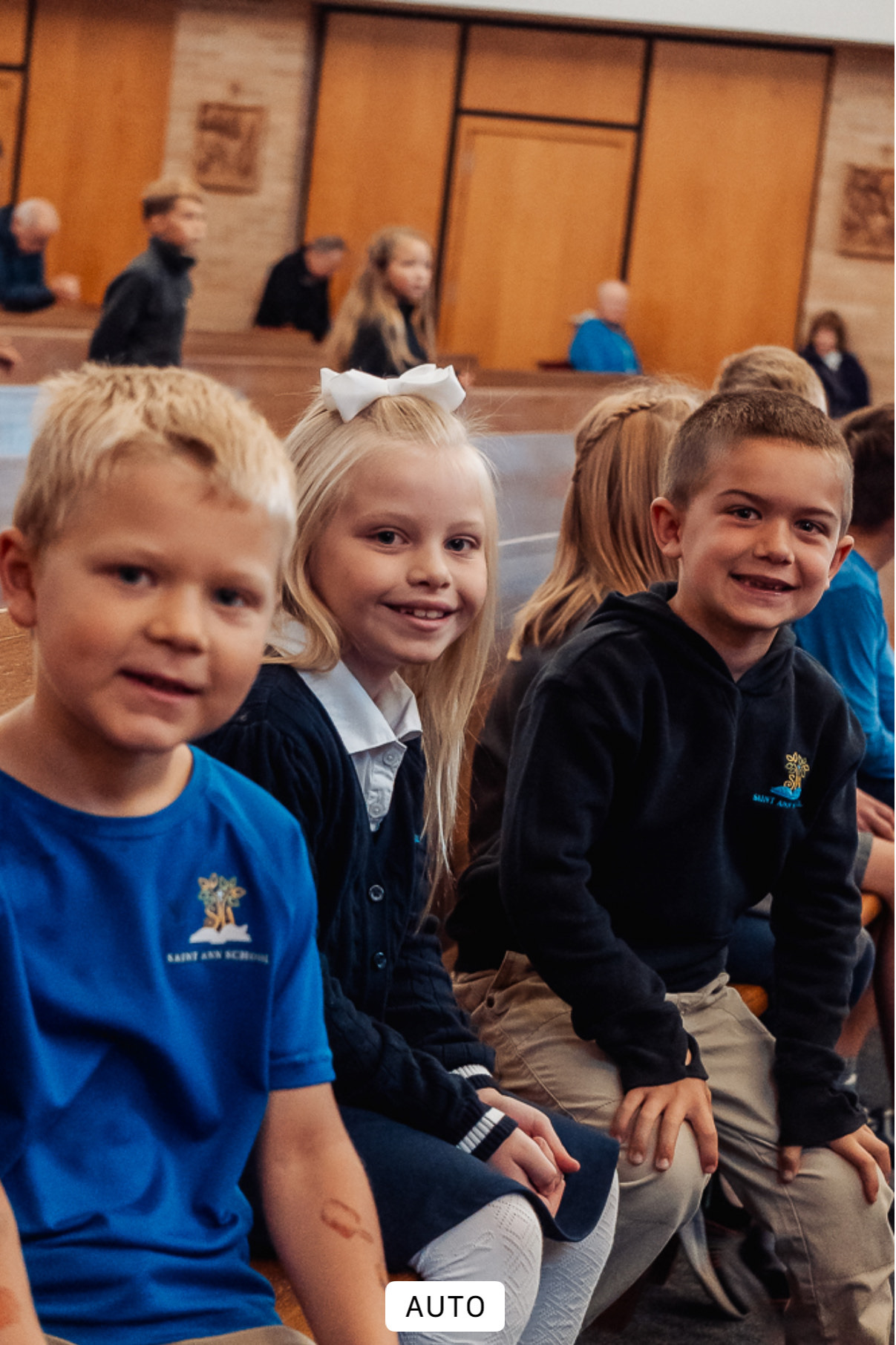 St. Ann School students smiling together during a school Mass for Religious Education
