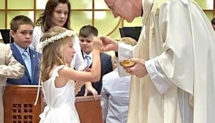 Students receive the body of Christ at St. Thérèse Academy