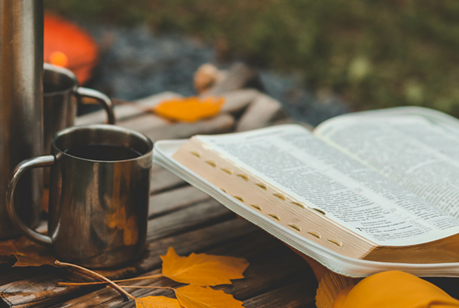 autumn leaves and hands holding a bible